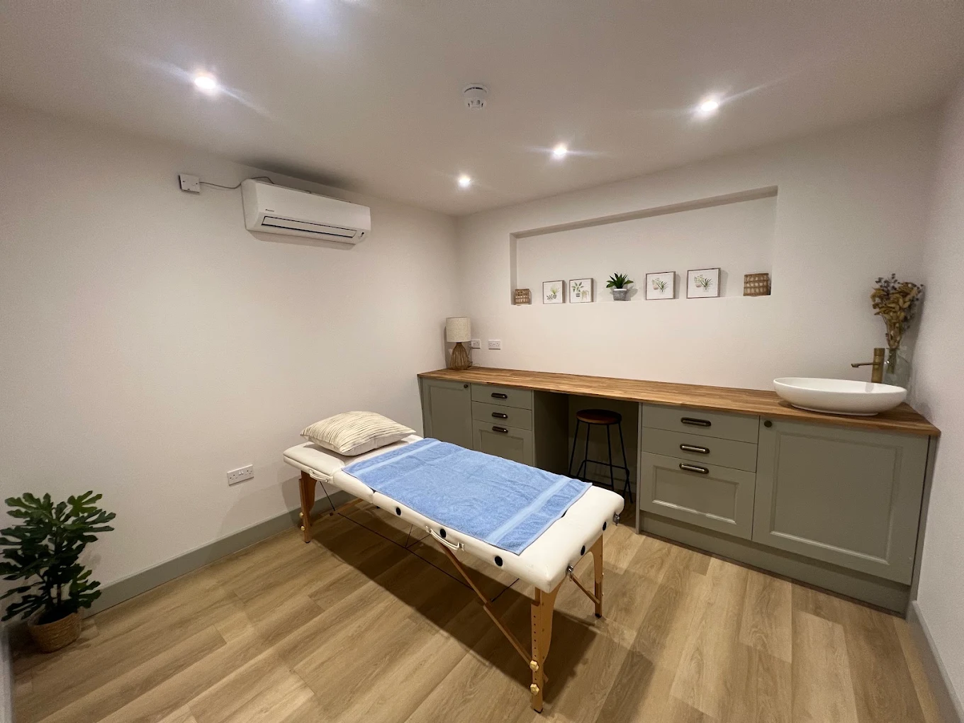 Treatment room with adjustable bed, oak worktop and basin